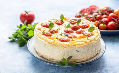 Naneli, mavi arkaplanlı domatesli tuzlu peynirli kek..