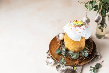 Geleneksel Ortodoks tatlı ekmeğiyle Paskalya kompozisyonu. Kulich krema, şeker serpintisi ve okaliptüs ile süslenmiş..