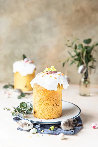 Easter composition with traditional Orthodox sweet bread. Kulich decorated with meringue icing, sugar sprinkles and eucalyptus. — Stock Photo, Image