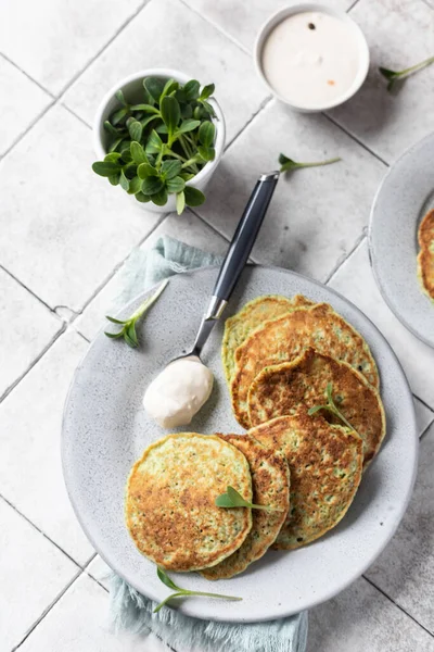 Plantaardige beignets geserveerd met verse kruiden en dip, betegelde achtergrond. Vegetarische broccoli of spinazie pannenkoeken. Bovenaanzicht. — Stockfoto