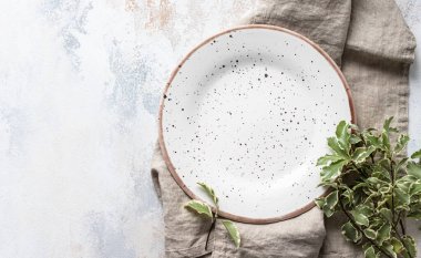 Açık arkaplanda yeşil yapraklı boş bir araç plakası. Bahar şatafatlı sofra, restoran menüsü konsepti. Yemek yerleştirme için maket. Şen minimalist konsept. Düz konum, tasarım için boşluk kopyala.