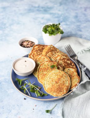 Sebzeli börek ya da kabaktan yapılmış krep, brokoli ya da mikroyeşil soslu ıspanak, mavi beton arka plan. Sağlıklı vejetaryen yemekleri.