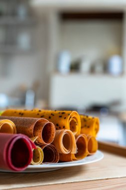 Seramik tabakta meyve ve böğürtlen şekerlemesi çeşitleri. Pastille meyveli rulo. Sağlıklı çiğ tatlılar. Diyet vitamin ve vejetaryen yemekleri..