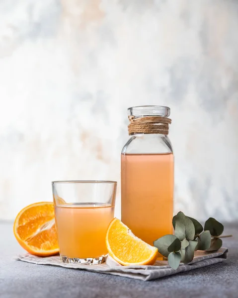 Orangenlimonade Glas Und Flasche Mit Frischem Orangefarbenem Betonhintergrund Erfrischendes Sommergetränk — Stockfoto