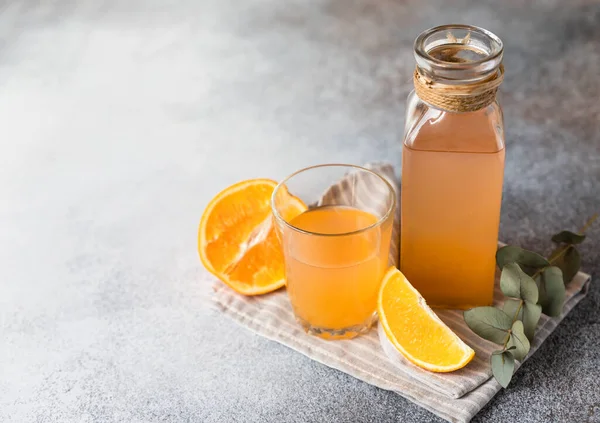 Orangenlimonade Glas Und Flasche Mit Frischem Orangefarbenem Betonhintergrund Erfrischendes Sommergetränk — Stockfoto