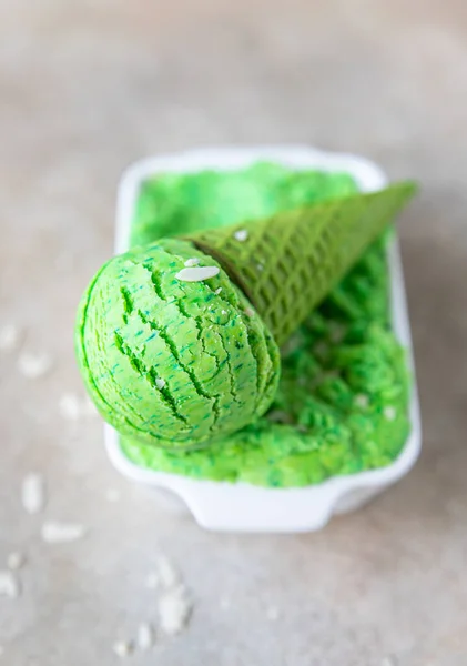 Green ice cream with lime and mint in green waffle cone. Summer dessert. Top view.