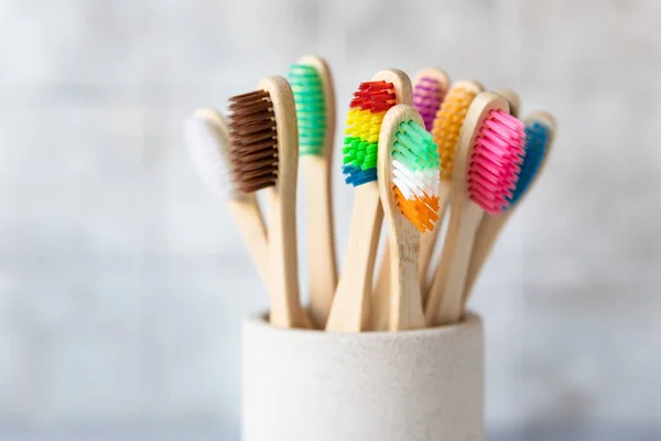 Cepillos de dientes de bambú coloridos en taza. Cepillos de madera ecológicos. Cero residuos, libre de plástico, ecológico concepto de producto orgánico. De cerca.. Fotos de stock