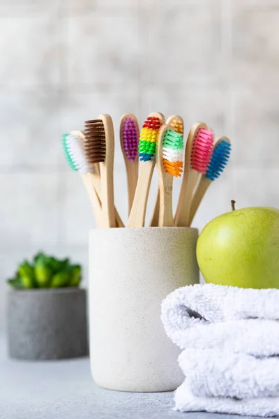 Cepillos de dientes de bambú en taza con toalla de algodón blanco, planta y manzana verde. Productos biodegradables para el cuidado personal. No hay conceptos plásticos. Fotos de stock libres de derechos