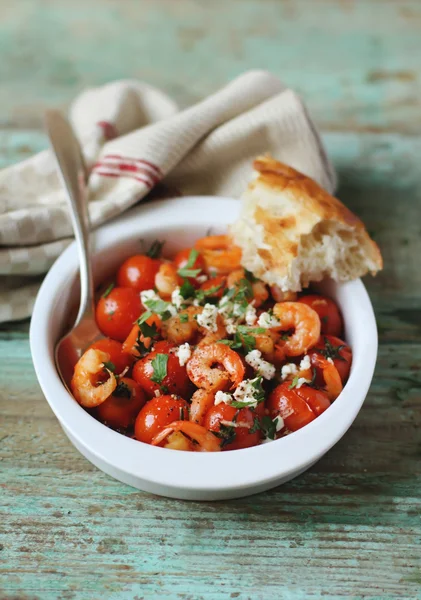 Portion of baked cherry tomatoes and roasted shrimps