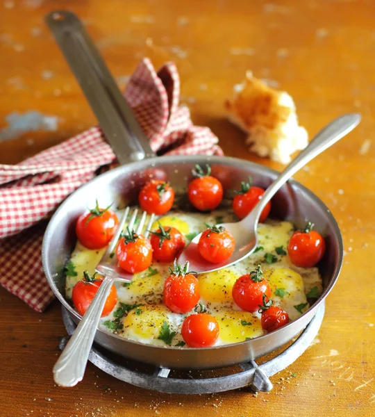 Sunny side up fried quail eggs with roasted cherry tomatoes