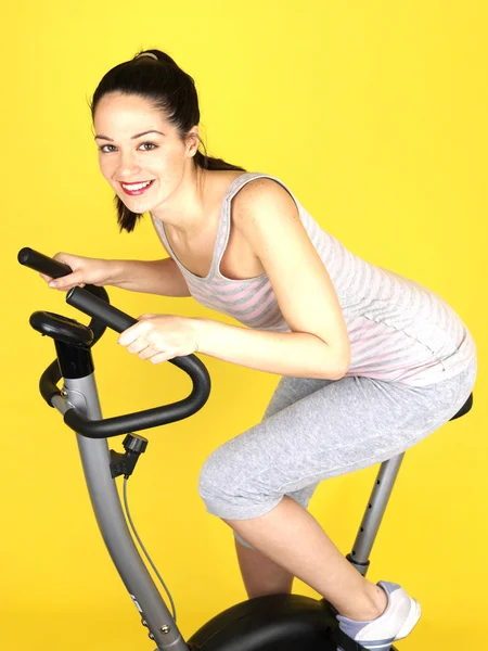 Jeune femme utilisant le vélo d'exercice — Photo