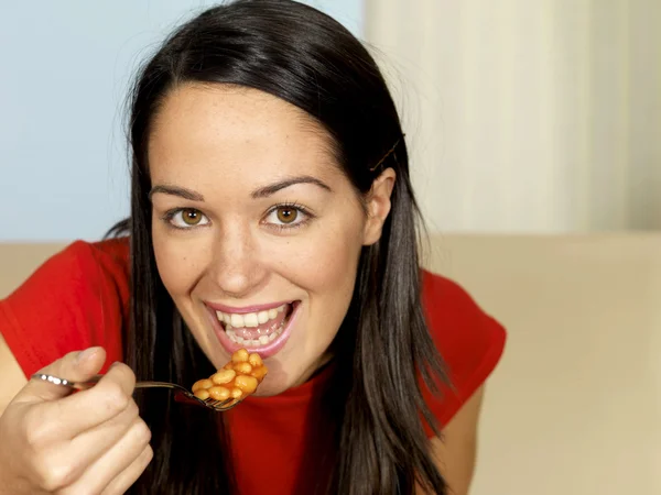 Mladá žena jíst pečené fazole — Stock fotografie
