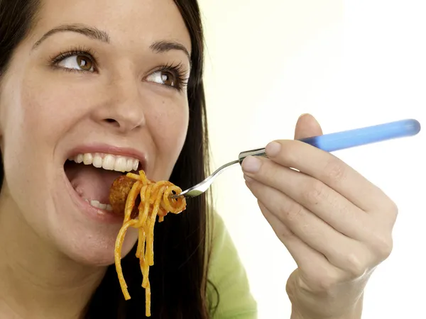 Mujer joven comiendo espaguetis y albóndigas — Foto de Stock