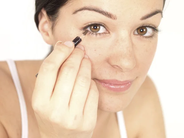 Jonge vrouw aanbrengen eyeliner — Stockfoto