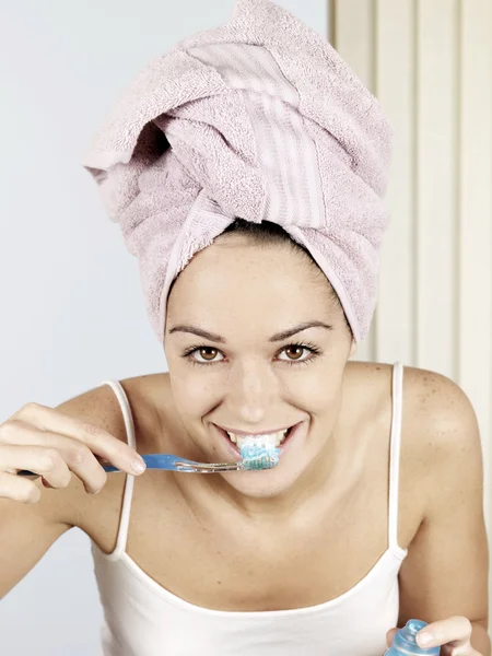 Mujer joven cepillándose los dientes — Foto de Stock