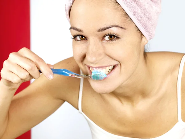 Jonge vrouw poetsen tanden Stockafbeelding