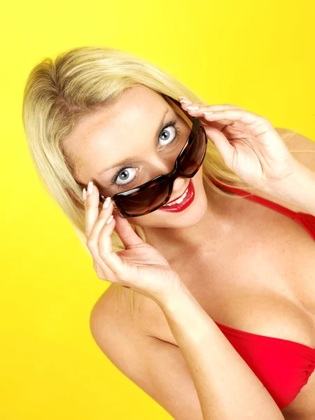 Glad ung kvinna klädd i bikini och solglasögon — Stockfoto