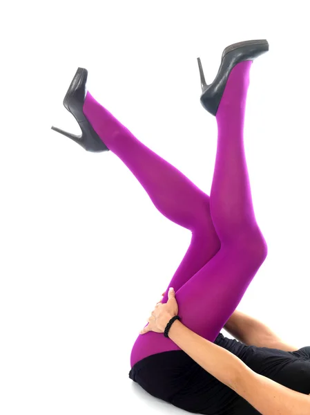 Женские ноги в розовых колготках на высоких каблуках и мини-юбке — стоковое фото