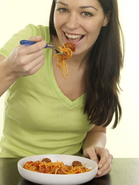 Junge Frau isst Spaghetti und Frikadellen Stockfoto