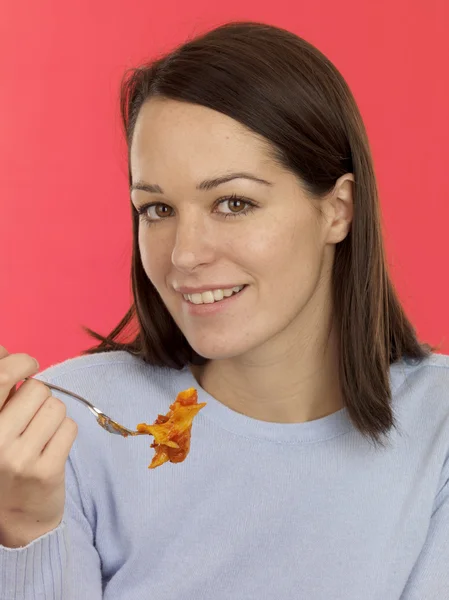 Jovem mulher comer macarrão assar — Fotografia de Stock