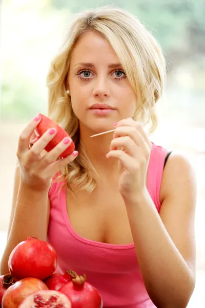 Tonårig flicka äter granatäpple — Stockfoto