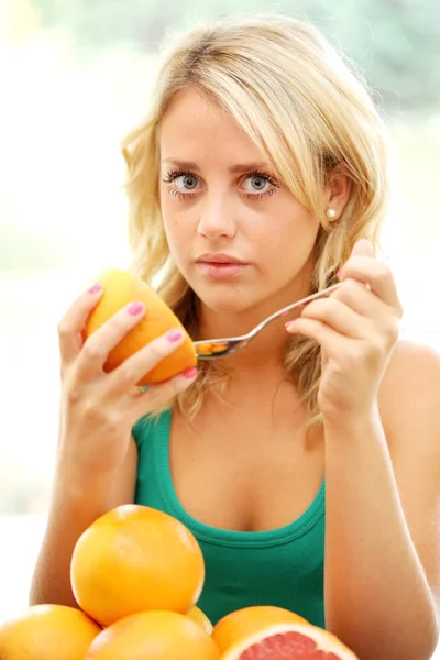 Девочка-подросток ест розовый грейпфрут — стоковое фото