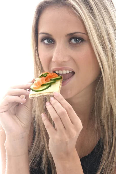 Mladá žena jíst uzený losos chleba se sýrem — Stock fotografie