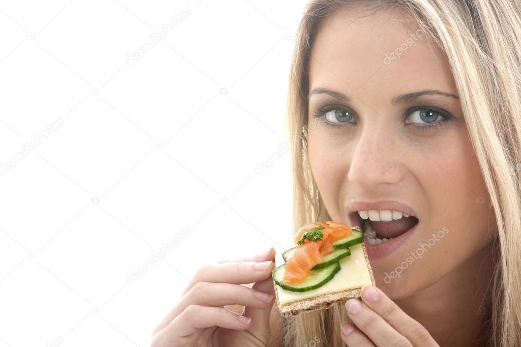 Young Woman Eating Smoked Salmon on a Cracker with Cheese