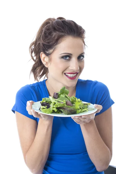 Jovem mulher atraente comendo salada de folhas verdes — Fotografia de Stock