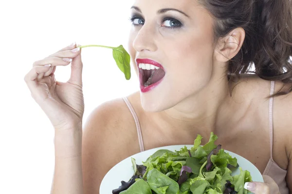 Jovem mulher atraente comendo salada de folhas verdes — Fotografia de Stock