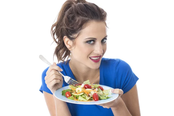 Atractiva mujer joven comiendo ensalada mixta —  Fotos de Stock