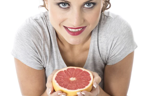 Jovem mulher atraente segurando toranja rosa — Fotografia de Stock