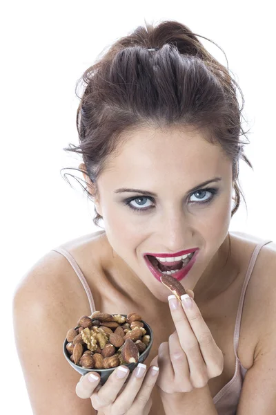 Attraente giovane donna mangiare noci miste — Foto Stock