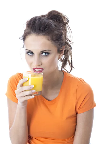 Attraktive junge Frau trinkt Orangensaft — Stockfoto