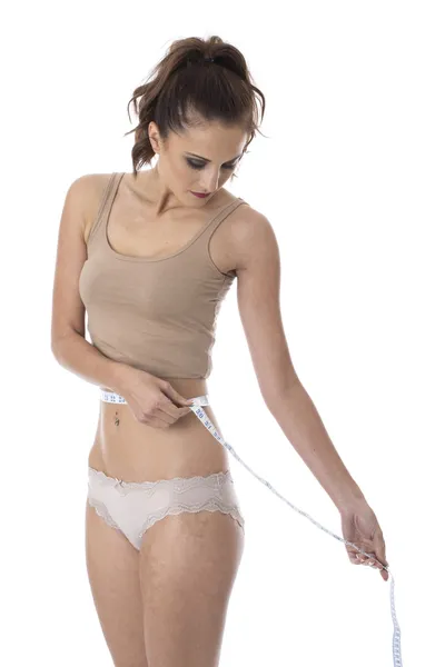 Jovem atraente mulher medindo sua cintura — Fotografia de Stock