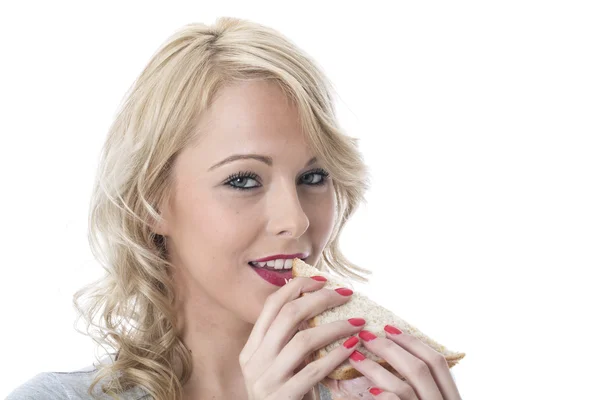 Mladá žena jíst sendvič — Stock fotografie