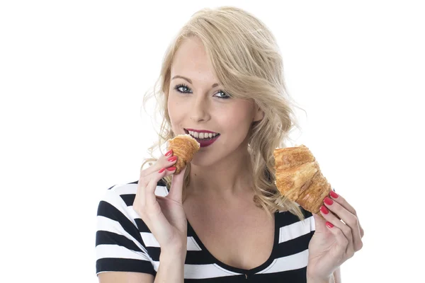 Mladá žena jíst snídani croissant — Stock fotografie