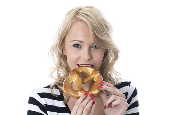 Mujer joven comiendo un pretzel — Foto de Stock