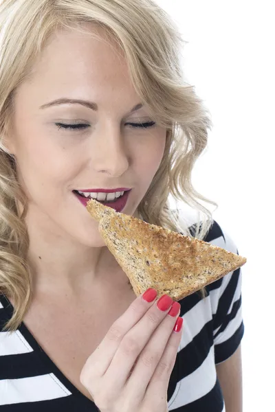 Mujer joven comiendo una rebanada de pan tostado — Foto de Stock