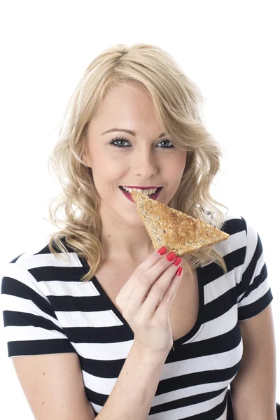 Jovem mulher comendo uma fatia de torrada — Fotografia de Stock