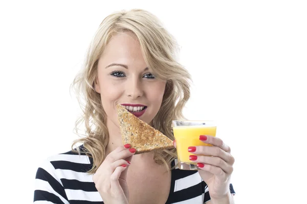 Mujer joven con tostadas y zumo de naranja —  Fotos de Stock