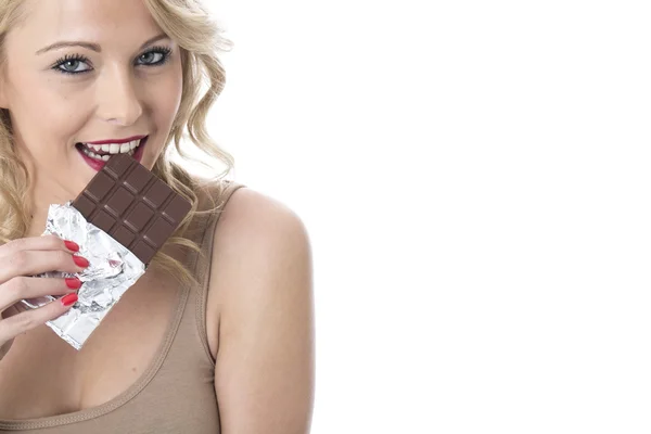 Attraente giovane donna mangiare una tavoletta di cioccolato — Foto Stock