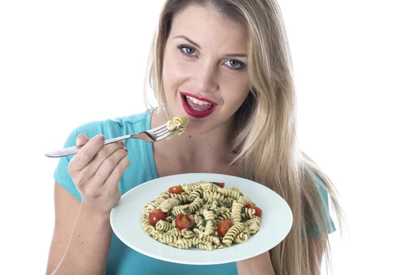 Młoda kobieta jedzenie makaron szpinak i Jądro orzechów cedrowych — Zdjęcie stockowe