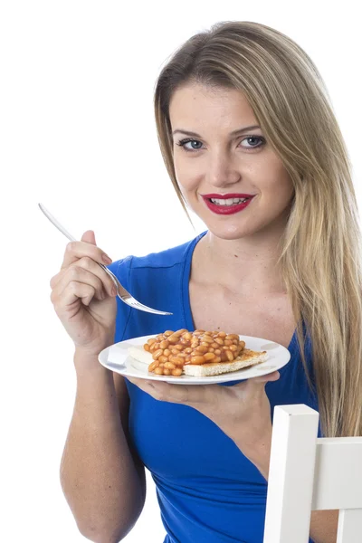 Mladá žena jíst pečené fazole na toastu — Stock fotografie