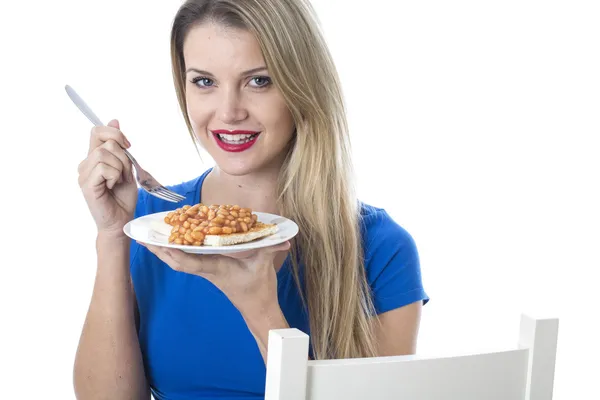 Młoda kobieta jedzenie fasolki na grzance — Zdjęcie stockowe