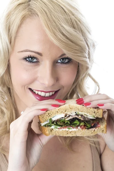 Çekici bir genç kadın bir sandviç yeme — Stok fotoğraf