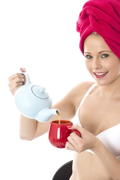 有魅力的年轻女人浇筑从一个茶壶茶 — 图库照片