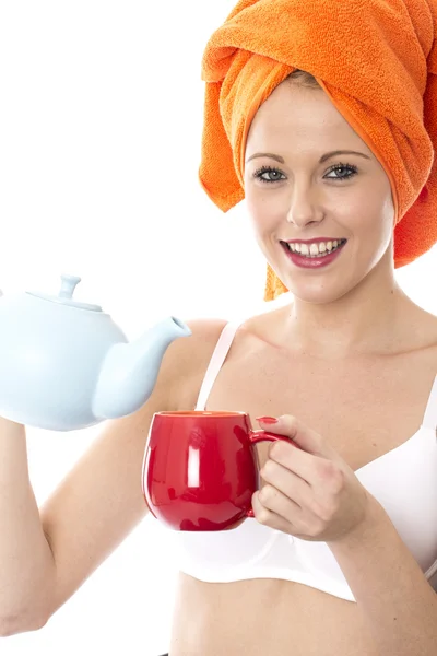 Attraktive junge Frau gießt Tee aus einer Teekanne — Stockfoto