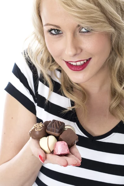 Atraente jovem mulher comer chocolates — Fotografia de Stock