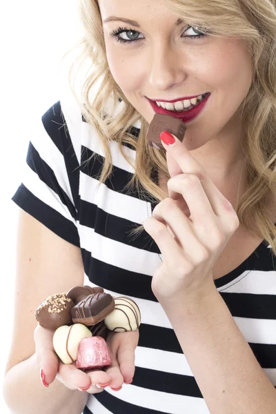 Atraente jovem mulher comer chocolates — Fotografia de Stock